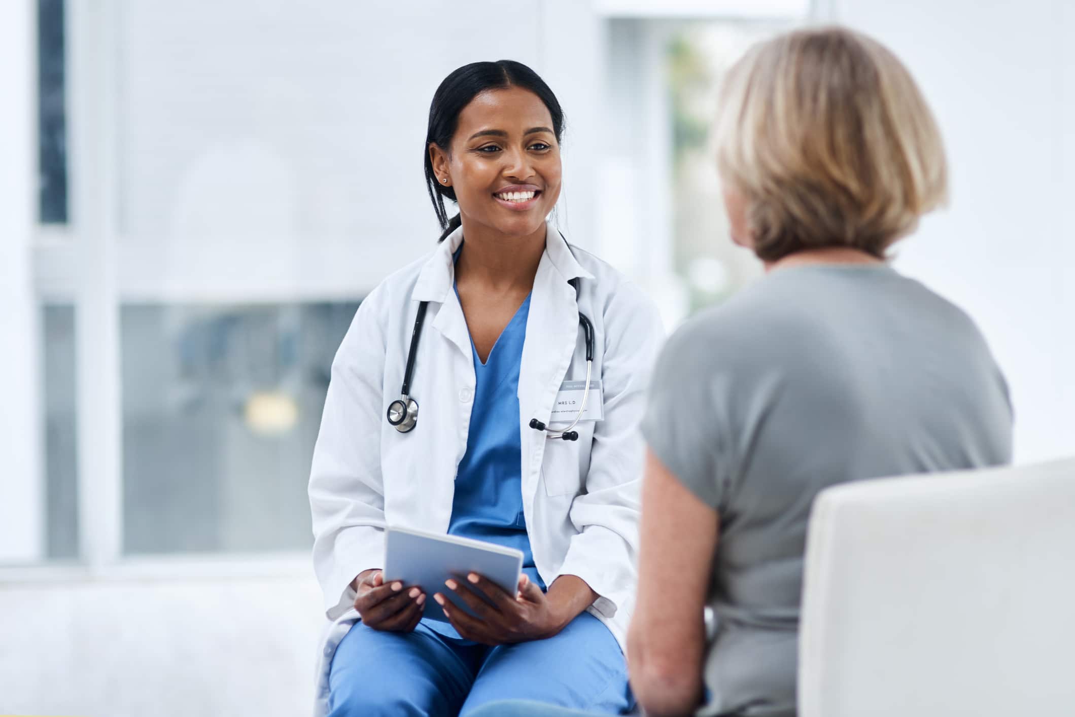 woman doctor smiling with female patient