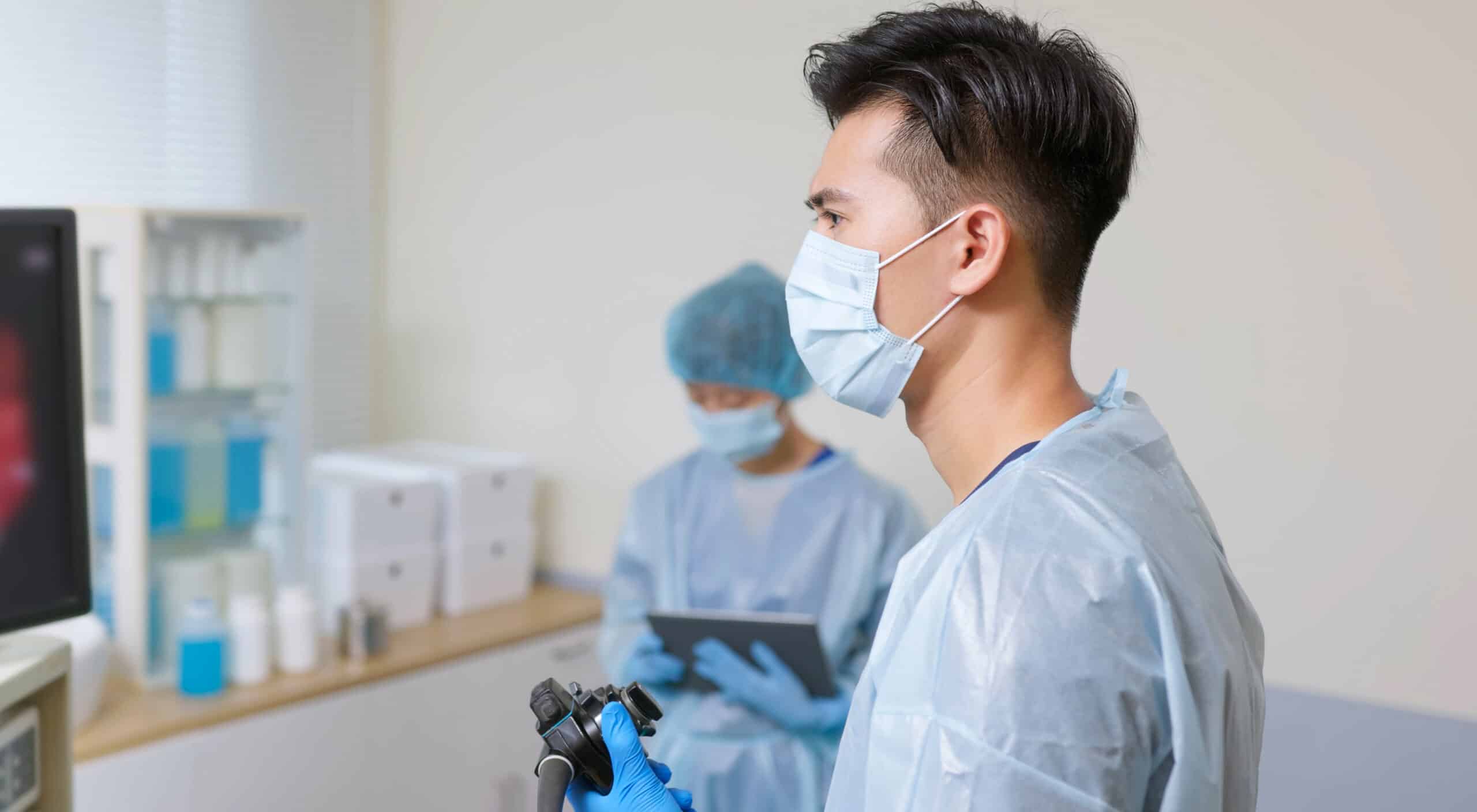 masked surgeon looking at screen